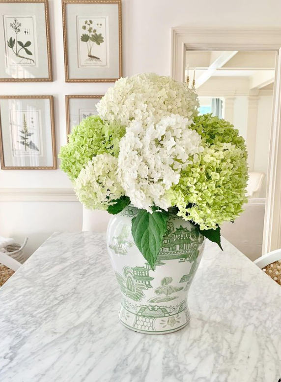 How to decorate with ginger jars. green and white ginger jar with flowers on kitchen counter.
