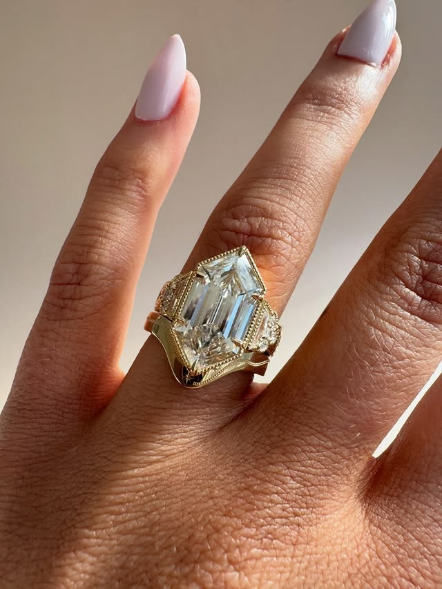 Elongated hexagon cut yellow gold unique diamond engagement ring.