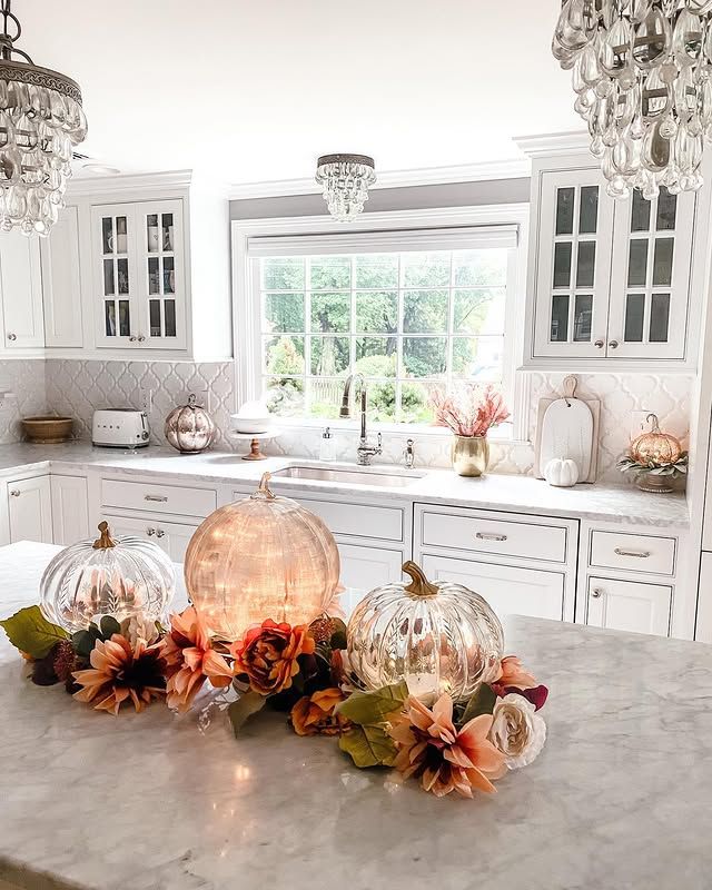 Fall kitchen counter decor with glass pumpkins and lights.
