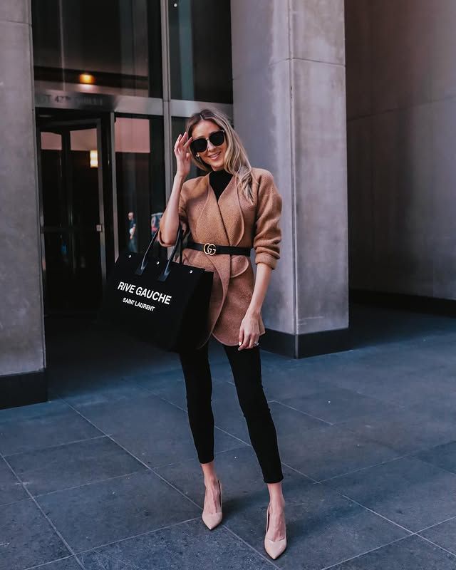 Belted camel colored coat for fall with black leggings.