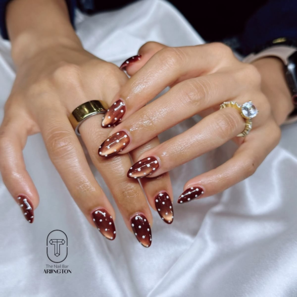 Brown and white fall polka dot almond nails in glass finish