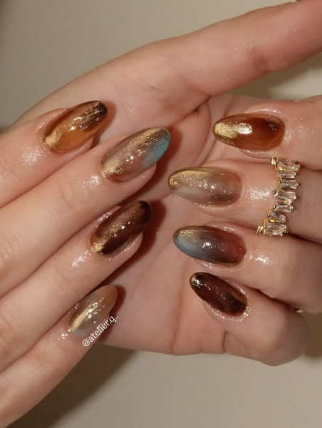 Fall marble nail design in brown, gold and green colors.