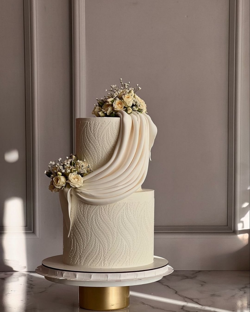 Patterned wedding cake with draped fondant details. Patterned wedding cake with draped fondant details.