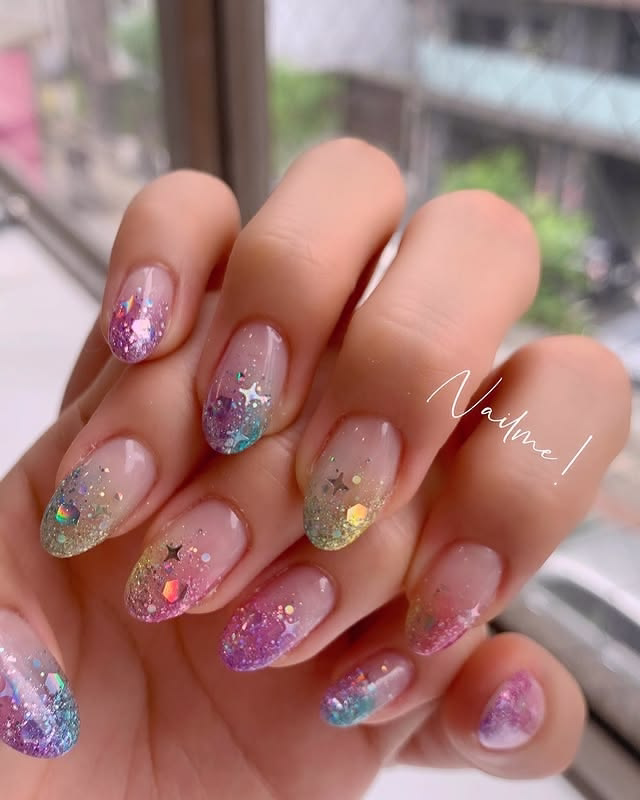Nude nails with colorful glitter tips with stars.