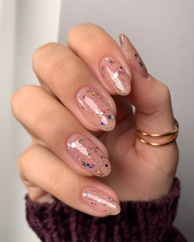 Nude nails with colorful glitter.