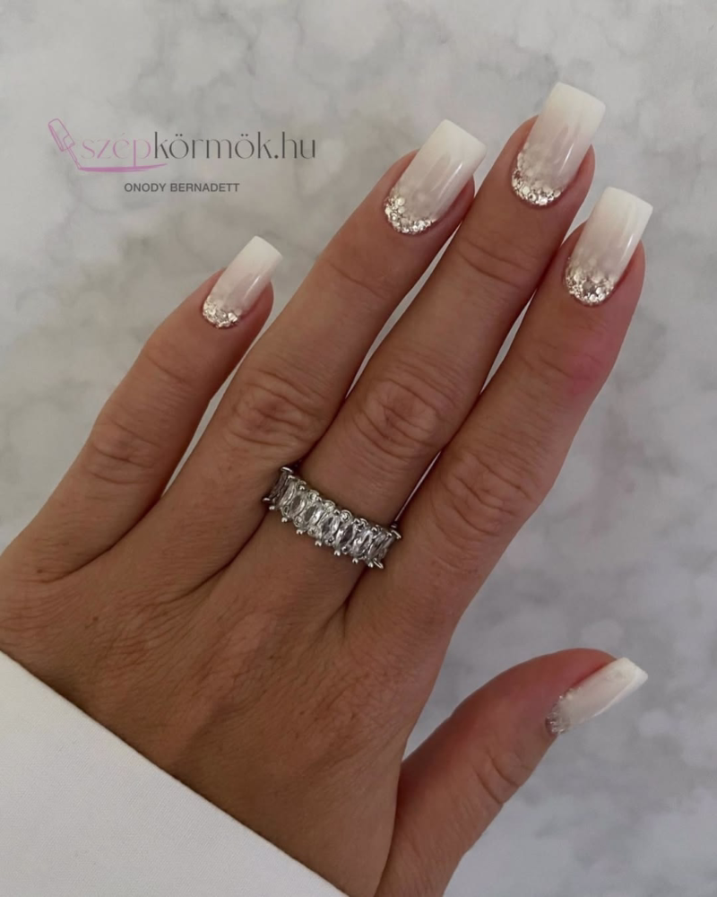 White nails in square shape with glitter above cuticles.